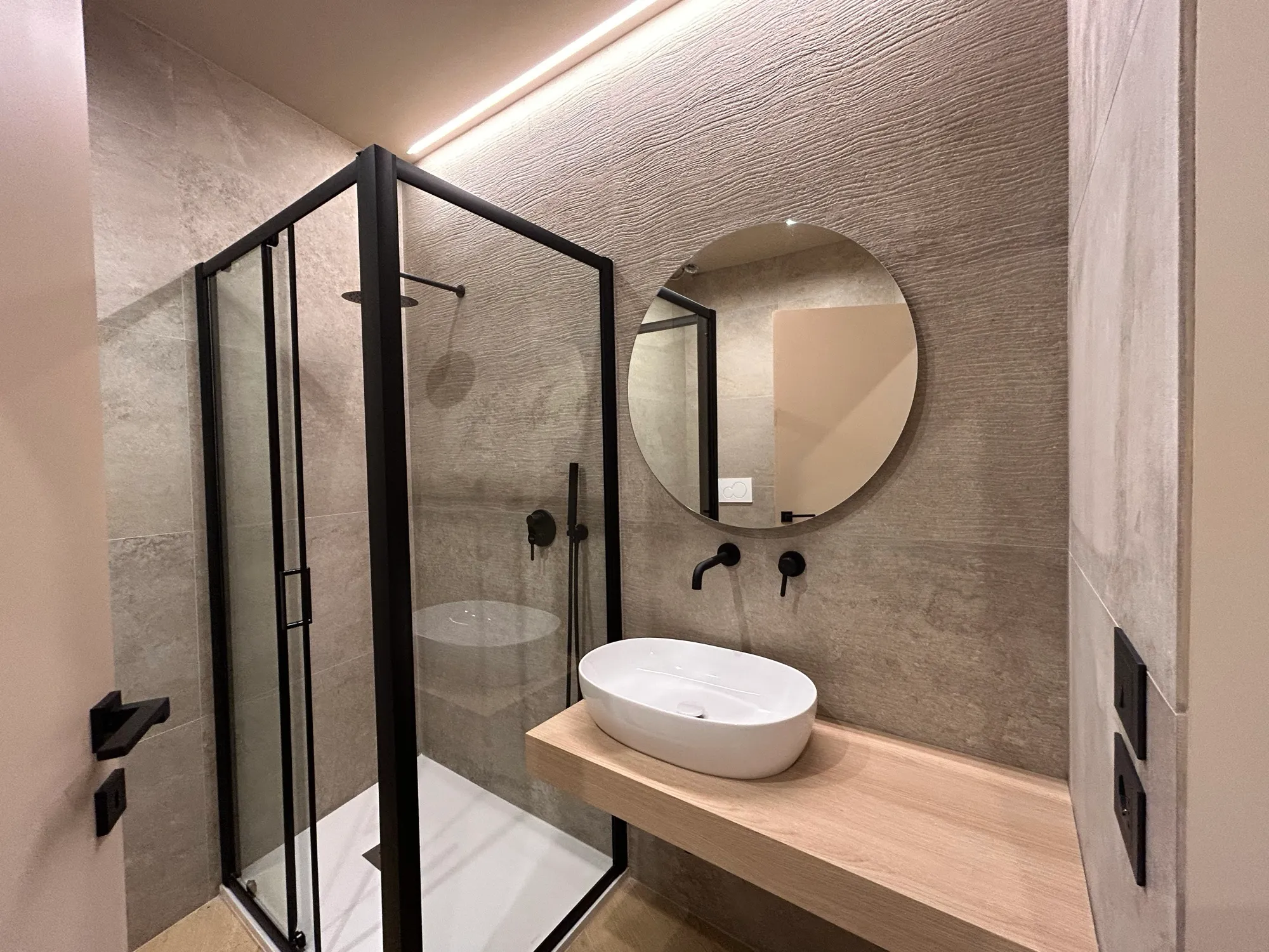 Bagno ristrutturato con box doccia in vetro e finiture in microcemento in un immobile valorizzato da Meta Compass a Ragusa